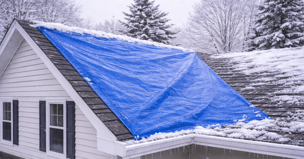 blue tarp on a roof to mitigate a leak during the winter